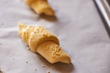 Mükemmel şekilli kruvasanlar güneş doğarken sıcacık bir mutfak ortamında pişmeye hazır.