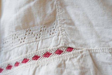 Eski geleneksel Ukrayna nakışlı gömleği. Vyshyvanka. Kırmızı geometrik desenli ve karmaşık dantel işçilikli beyaz kumaş üzerine ayrıntılı nakış. Geleneksel işçilik sergileniyor.