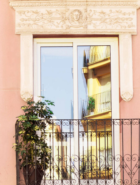 Openwork balcony. Beautiful reflection of the street in the door. Alicante. High quality photo