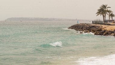 Bulutlu bir günde Akdeniz. Uzakta bir sahil ve bir yelkenli var. Yüksek kalite fotoğraf