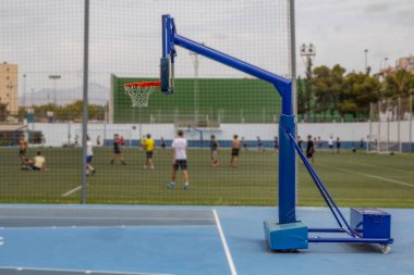 Basketbol oynamak için bir sepetin yanında dur. Arka planda stadyum olan bir açıdan yan görüş. Arka plan bulanık. Yüksek kalite fotoğraf