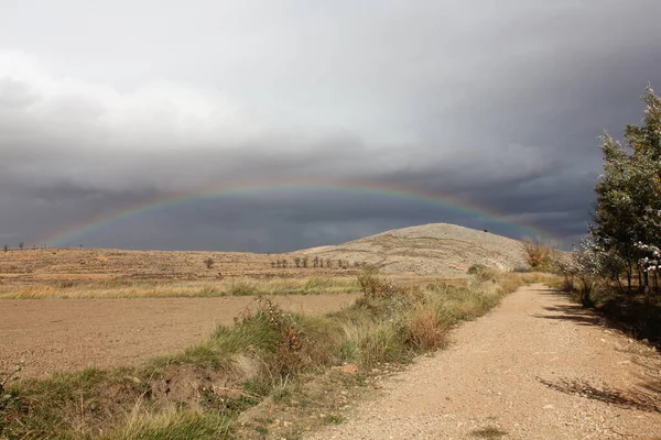 Teruel madencilik havzalarında yağmurdan sonra gökkuşağı, kurak ve kırsal bir arazi.