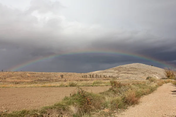 Teruel madencilik havzalarında yağmurdan sonra gökkuşağı, kurak ve kırsal bir arazi.