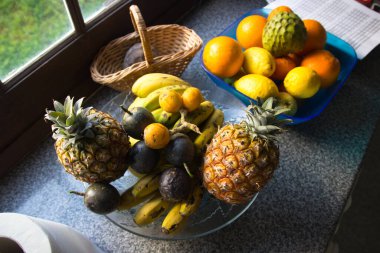 Cam vazoda bir sürü tropikal meyve var. Egzotik meyveler: averrhoa carambola, Pitahaya, Mango, Plantain, mandalina, nar meyvesi. yeşil arka plan. Yüksek kalite fotoğraf