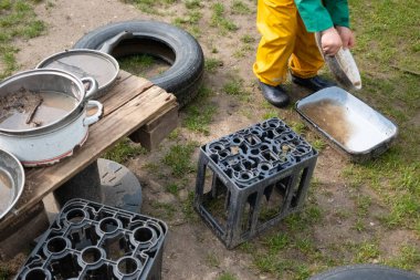 Çocukların serbest oyun oynadığı bir anaokulunda, kum, su, çamur ve yapraklarla dolu tencere, tava ve tabaklarla dolu canlı bir çamur mutfağı. Montessori 'den esinlenilmiş elle öğrenme.