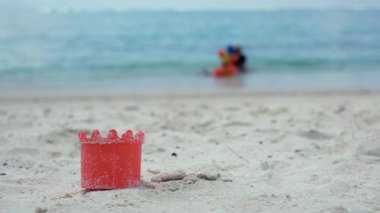Kumsaldaki kırmızı plastik şişe.