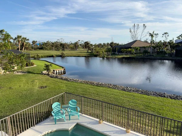 Florida home with back yard pool with blue skies. Rental property Florida. Lake surrounding