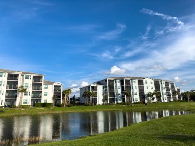 Florida 'nın güneybatısındaki bir golf sahasındaki huzurevleri. Su ve yemyeşil çimenlikli mavi gökyüzü