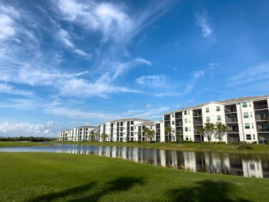 Florida 'nın güneybatısındaki bir golf sahasındaki huzurevleri. Su ve yemyeşil çimenlikli mavi gökyüzü