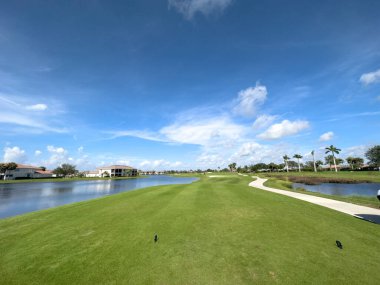 Mavi gökyüzü ve güneşli golf sahası. El değmemiş yemyeşil çimenlik çim ve su. Güneybatı Florida.