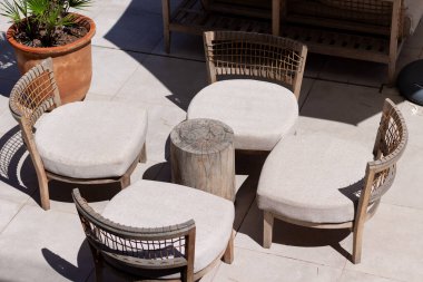 Ahşap kanepe ve sehpa rahat modern terasta, güneşli bir otelde teras.