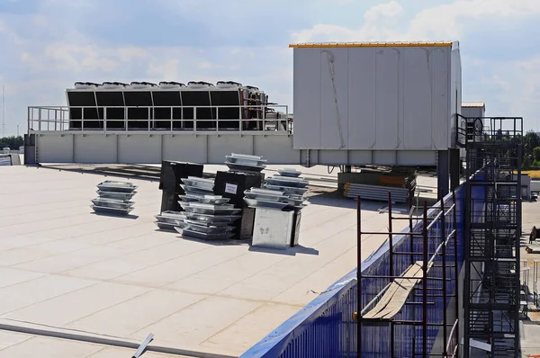 The process of building a warehouse from sandwich panels. A view of the membrane roof and the platform with ventilation equipment.
