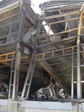 Burnt structures of the metal frame of an industrial building after a fire. Deformations of columns and beams from high temperature.