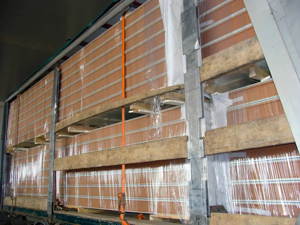 The cargo trailer is loaded with sandwich panels for warehouse construction. Panels with insulation are shipped from the machine to the construction site.