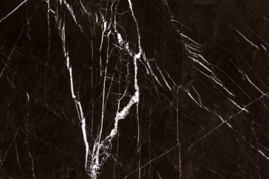 Geniş format desen, beyaz damarlı siyah mermer ve uzun çatlaklar.