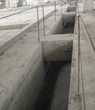 Endüstriyel bir binanın zemininde beton kanallar var. İnşaat alanında gerçek bir manzara..