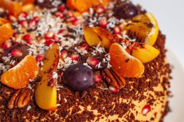 Çikolata parçacıklı el yapımı pasta ve taze meyve süslemesi, beyaz arka planda küçük ve yakın plan..