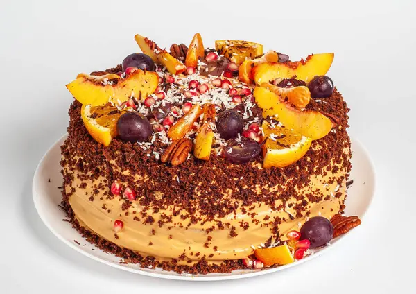 Handmade cake with chocolate sprinkled and decoration with fresh fruit, on white background.