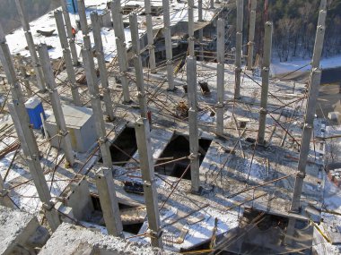 Geçmişteki beton elementler binanın yukarıdan görüntüsünü güçlendirdi. İnşaat alanındaki sütunlardan ve levhalardan oluşan bir çerçeve..