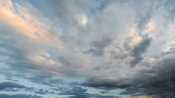 stock image Evening sky with dramatic clouds in various shades and textures. A large panorama of the sky with beautiful clouds illuminated by soft sunlight.