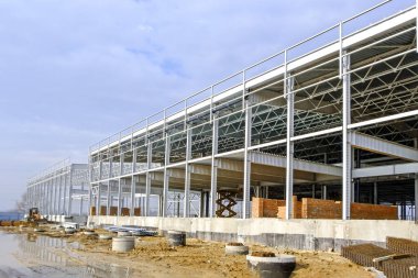 Çelik yapısı ve tuğla duvarları olan geniş bir sanayi tesisinin inşaatı.