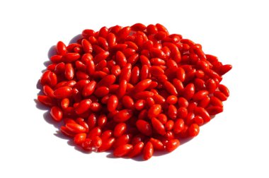 Goji üzümleri beyaz arka planda izole edilmiş, canlı kırmızı renkler ve desen sergiliyorlar..