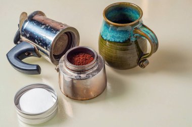 Kahve telvesi, bir yığın filtre ve kahve demlemeye hazır yeşil ve mavi seramik bardak ayrı bir Moka demliği..