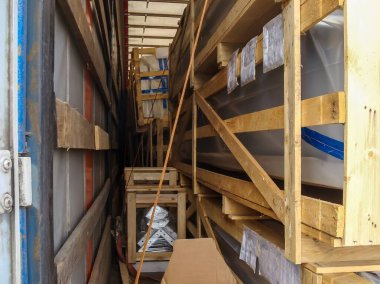 Paketlenmiş malzemeler ahşap sandıklar ve kayışlarla korunuyor. Kamyon römorkunda güvenli bir şekilde taşınmaya hazırlar..