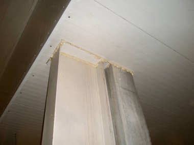 Odanın köşesinin düşük açılı bir çekimi boyalı bir sütunu ve tamamlanmamış bir inşaatı gösteriyor..