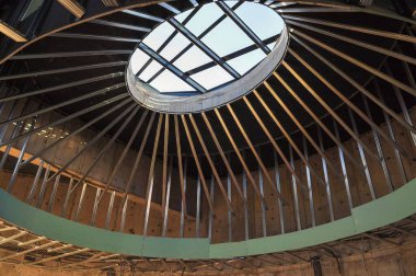 Metal iskelet ve çarpıcı bir oval tavan penceresinin yer aldığı modern bir bina tasarımı, gelişmekte olan mimari tasarımı yakalıyor.