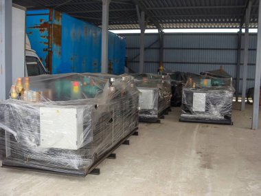 Birçok yeni endüstriyel makine plastik ambalaj altında, bir depoda kurulum ve kullanım bekliyor..