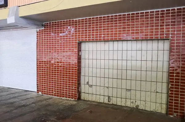 Kapalı kapısı olan fayanslı bir duvar, kentsel ya da endüstriyel bir ortamı çağrıştırıyor ve gizem ve kaplama hissi yaratıyor..