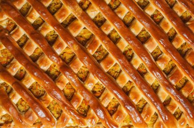 Ev yapımı bir pastanın genel çekimi altın bir kabuktur, aromalı bir dolgunun üzerine karmaşık bir şekilde örülmüştür, ve iştah açıcı bir görüntüsü vardır..