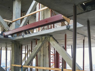 İnşaat sahasında beton kirişler ve destekleyici yapılar görülüyor. Görüntü, mimarinin inşaat sürecindeki ham elementlerini yakalar..