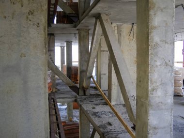 İnşaat halindeki bir binanın içinde, beton sütunlar ve destek kirişleri bitmemiş uzayın yapısal iskeletini oluşturur..