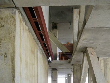 İç çekim, beton duvarlar ve metalle büyük bir binanın destekleyici yapısını gösteriyor..