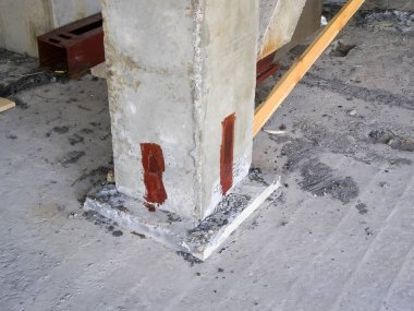 Endüstriyel ayar sağlam bir beton sütunu gösteriyor, potansiyel olarak inşaat halindeki bir binanın yapısal bir bileşeni..