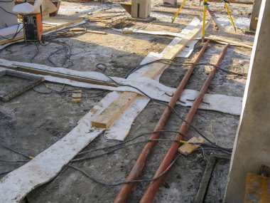 Bir inşaat sahasının genel görünümü, gündüz operasyonunda yerde düzenlenmiş çeşitli araç ve gereçleri göstermektedir..