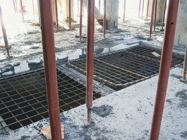 İnşaat alanının iç görüntüsünde beton, metal ızgara ve destek kirişleri görülüyor..