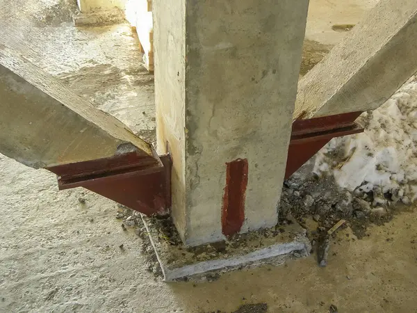 Yakın çekim, bitmemiş bir yapıda metal destekli beton destek sütunun tabanını gösterir.