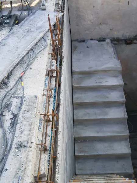 İnşaat alanı, inşaat ilerlemesini sembolize ederek inşaat demiri ve merdivenleriyle güçlendirilmiş beton yapıları gösteriyor..