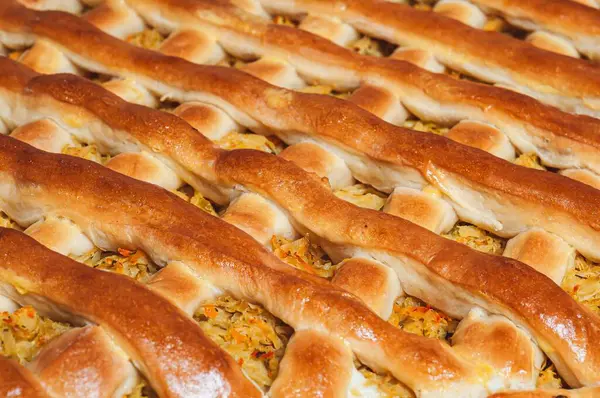 Karmaşık dokuma kabuğunu ve altındaki lezzetli dolguyu gösteren, altın sarısı bir kafes turtasının yakın çekimi..