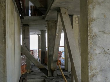 İnşaat halindeki bir binanın mimari detaylarıyla beton inşaat. Özellikler arasında sütunlar, kirişler ve destekleyici elementler yer alıyor.