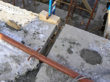 İnşaat alanı, çevresindeki destek iskeleleri ve borularla somut çalışmaların ayrıntılı sürecini yakalar.