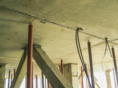 Bina inşaatı sırasında desteklenen beton tavanın alt tarafı. Elektrik kabloları asılı..
