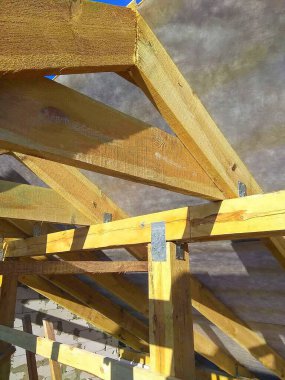 Ahşap çatı yapısının yakın görüntüsü. İnşaatta kullanılan kirişlere, desteğe ve inşaat bileşenlerine ayrıntılı bak.