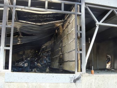 Binanın içi, yanmış duvarlar ve çökmüş bir çatıyı ortaya çıkaran bir yangından ciddi şekilde zarar görmüştür..