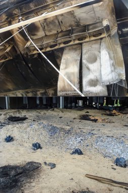 Yangından sonra yanan bir binanın ve endüstriyel soğutucuların kalıntılarını gösteren bir kolaj..