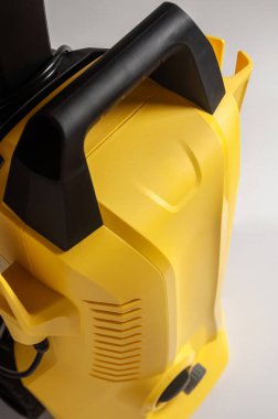 Siyah saplı sarı basınçlı bir çamaşır makinesinin yakın çekim görüntüsü tasarımını ve bileşenlerini gösteriyor..