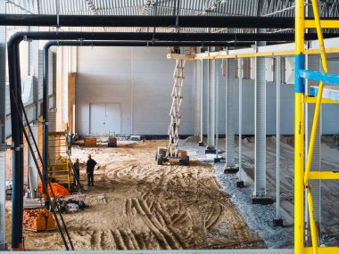 İnşaat alanı işçilerle, ekipmanlarla ve yapısal elementlerle.